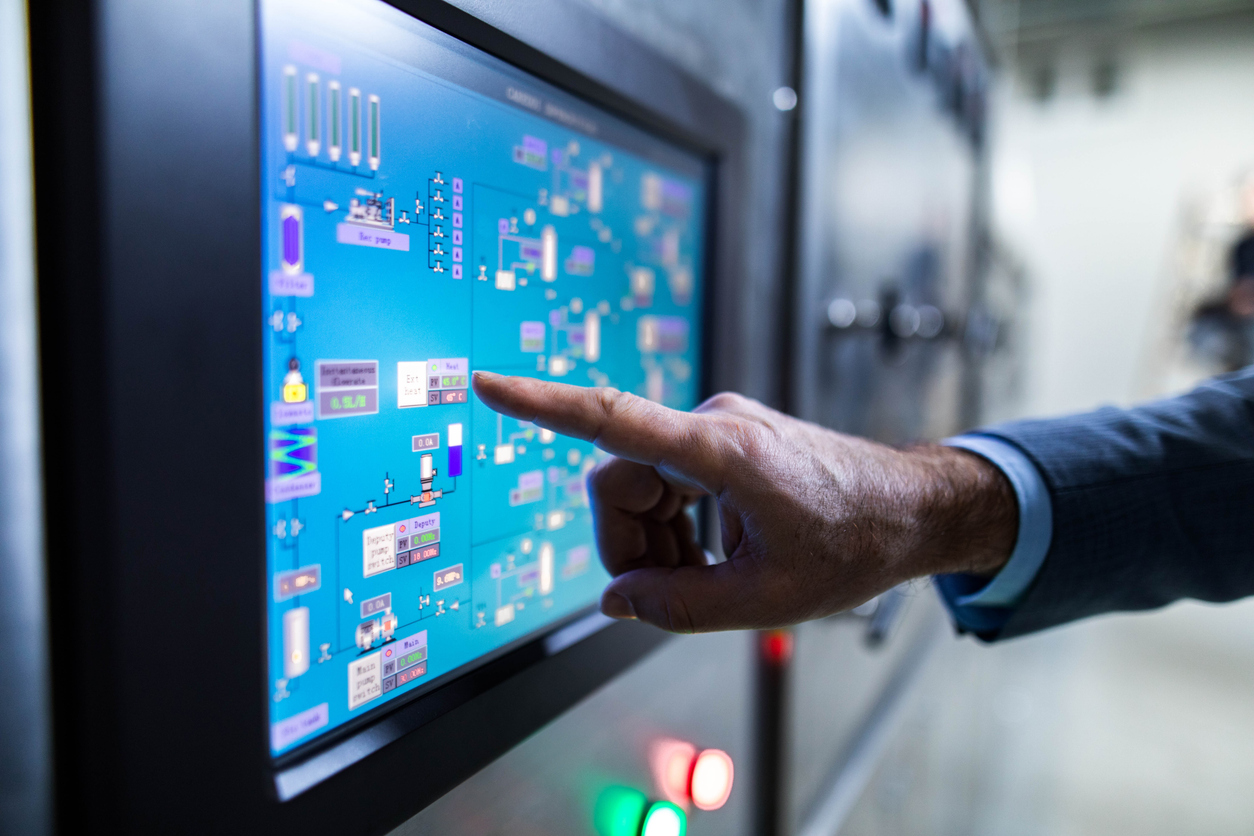Close up of an inspector working on touch screen of production machine.